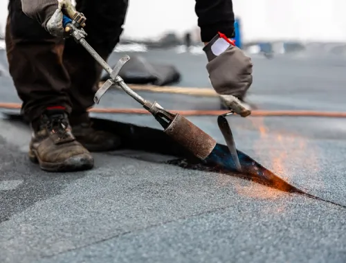 Roofers installing a watertight membrane