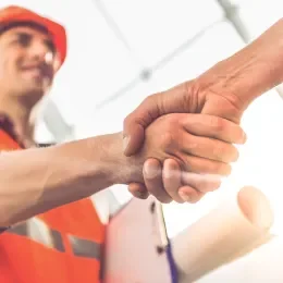 Project manager shaking hands with a homeowner to commence a new build